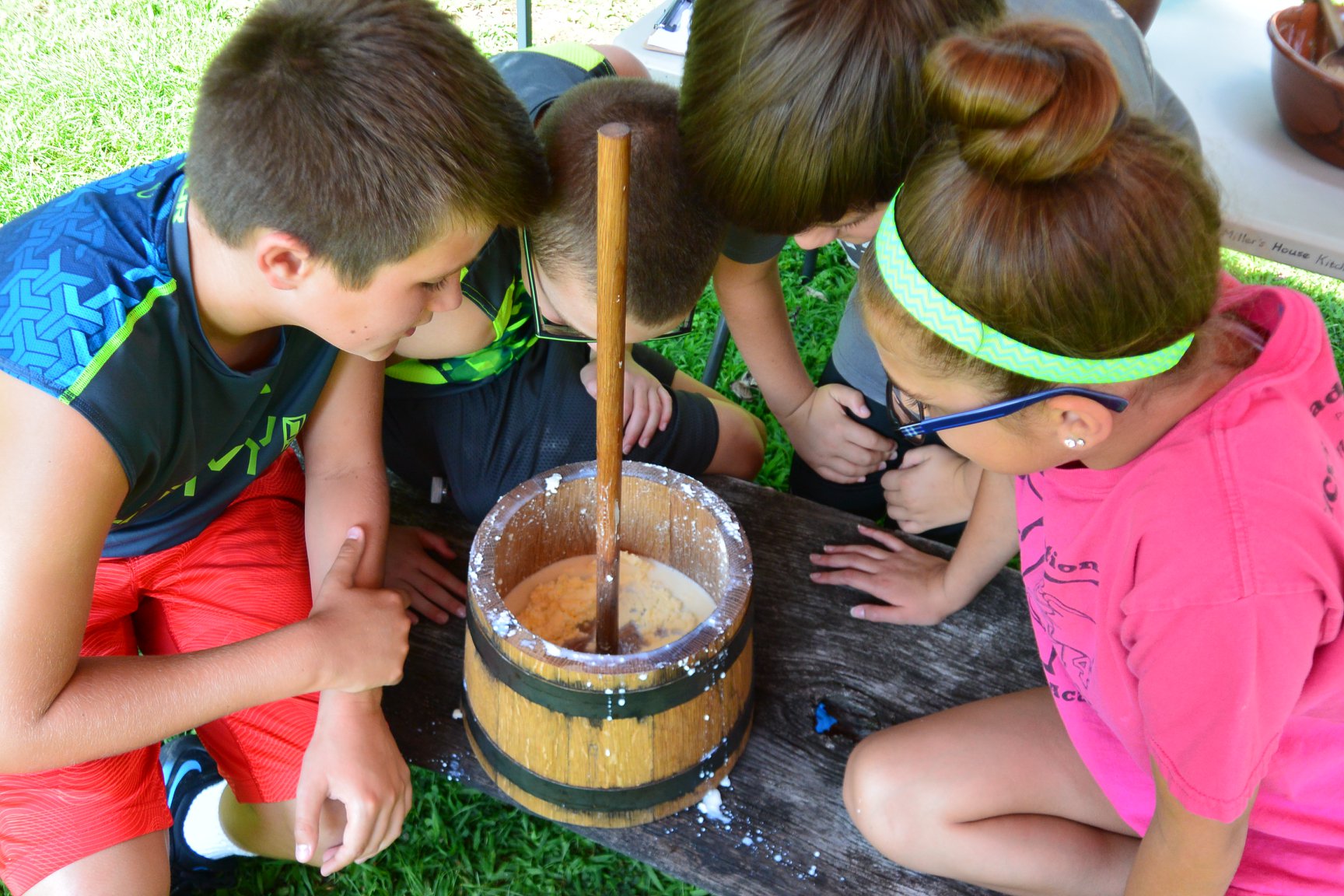 Four Children at Newlin Camp observing their butter churn