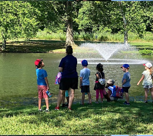 A group of kids with a counselor looking at a pond
